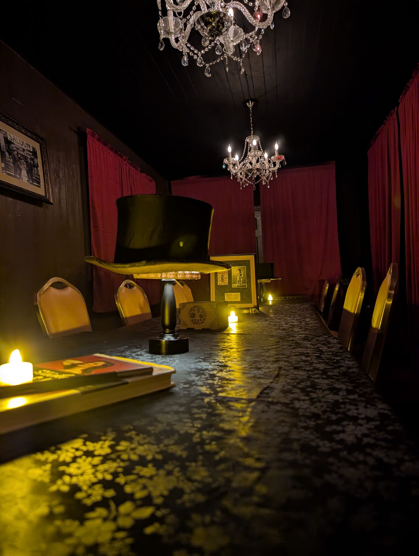 The candlelit back room at Capo's Speakeasy, Las Vegas — red curtains, chandeliers and set tables